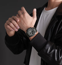 Load image into Gallery viewer, Person wearing a black leather jacket and a watch on a dark background