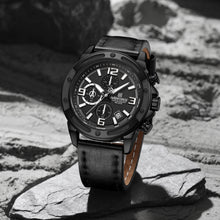 Load image into Gallery viewer, Black wristwatch with detailed face on a textured stone surface